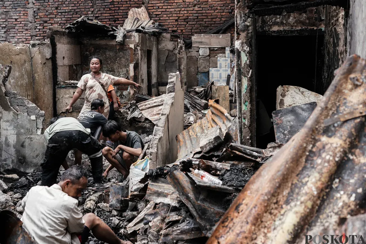 Warga membawa barang-barang yang masih bisa diselamatkan dari kebakaran di Senen, Jakarta Pusat, Senin, 15 September 2025. (Sumber: Poskota/Bilal Nugraha Ginanjar)