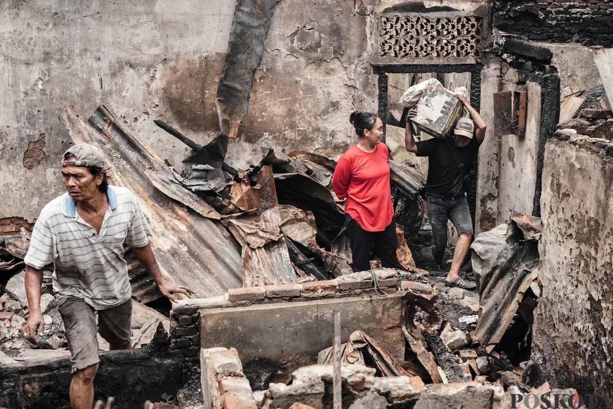 Warga membawa barang-barang yang masih bisa diselamatkan dari kebakaran di Senen, Jakarta Pusat, Senin, 15 September 2025. (Sumber: Poskota/Bilal Nugraha Ginanjar)