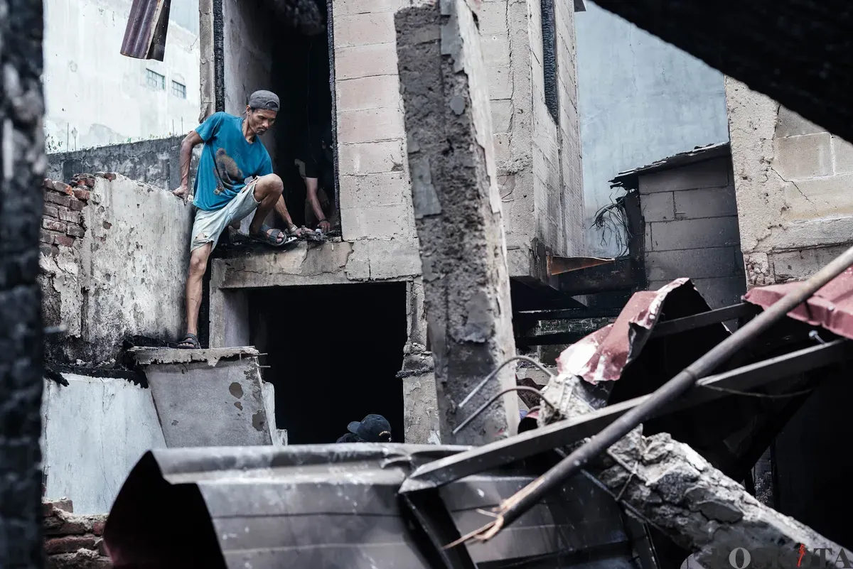 Warga membawa barang-barang yang masih bisa diselamatkan dari kebakaran di Senen, Jakarta Pusat, Senin, 15 September 2025. (Sumber: Poskota/Bilal Nugraha Ginanjar)