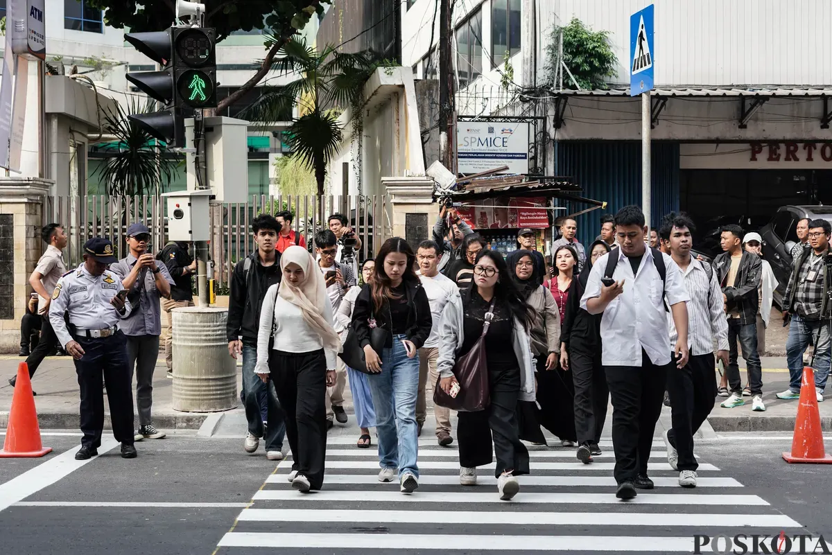 Warga menyeberang jalan menggunakan pelican crossing di sisi timur Stasiun Cikini, Jakarta, Senin, 15 September 2025. (Sumber: Poskota/Bilal Nugraha Ginanjar)