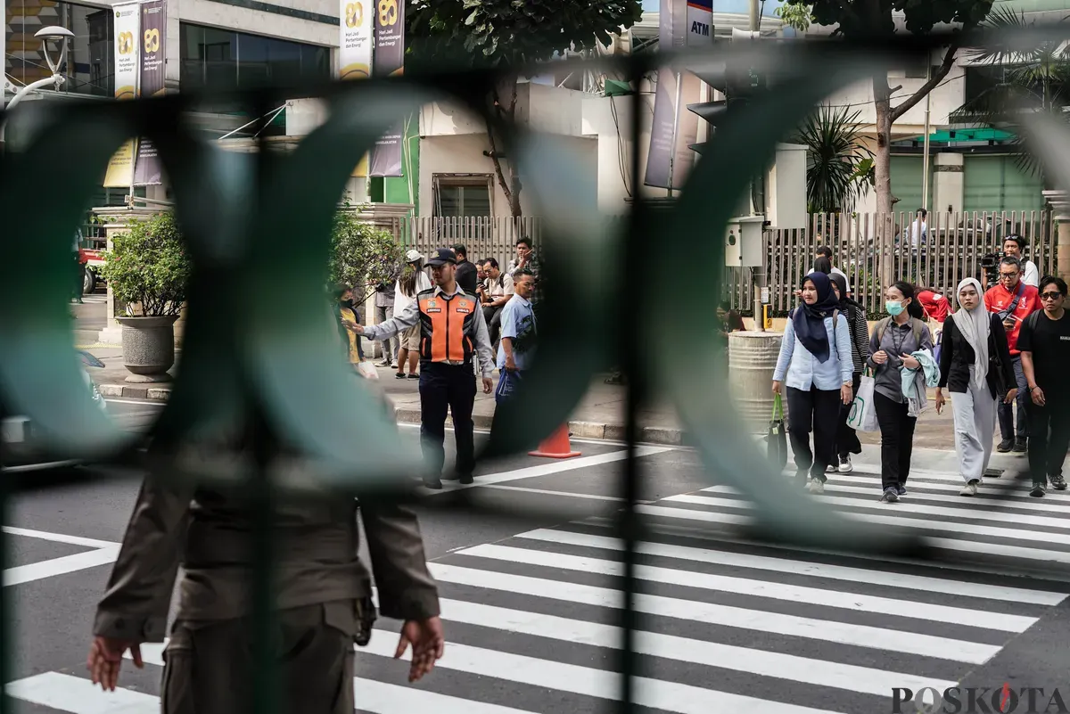 Warga menyeberang jalan menggunakan pelican crossing di sisi timur Stasiun Cikini, Jakarta, Senin, 15 September 2025. (Sumber: Poskota/Bilal Nugraha Ginanjar)