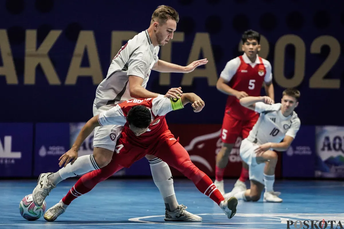Pemain Timnas futsal Indonesia Mochammad Iqbal  berebut bola dengan pemain Timnas futsal Latvia Artjoms Troickis pada turnamen AQUA Futsal Four Nations Cup 2025 di GBK Basket Hall, Senayan, Jakarta, Minggu (21/9/2025). (Sumber: Poskota/Bilal Nugraha Ginanjar)