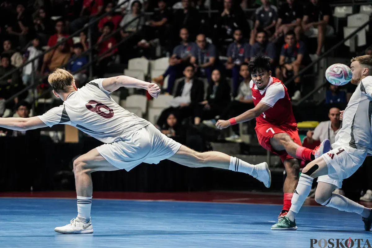 Pemain Timnas futsal Indonesia Syauqi Sa'ud menendang bola melwati pemain Timnas futsal Latvia pada turnamen AQUA Futsal Four Nations Cup 2025 di GBK Basket Hall, Senayan, Jakarta, Minggu (21/9/2025). (Sumber: Poskota/Bilal Nugraha Ginanjar)