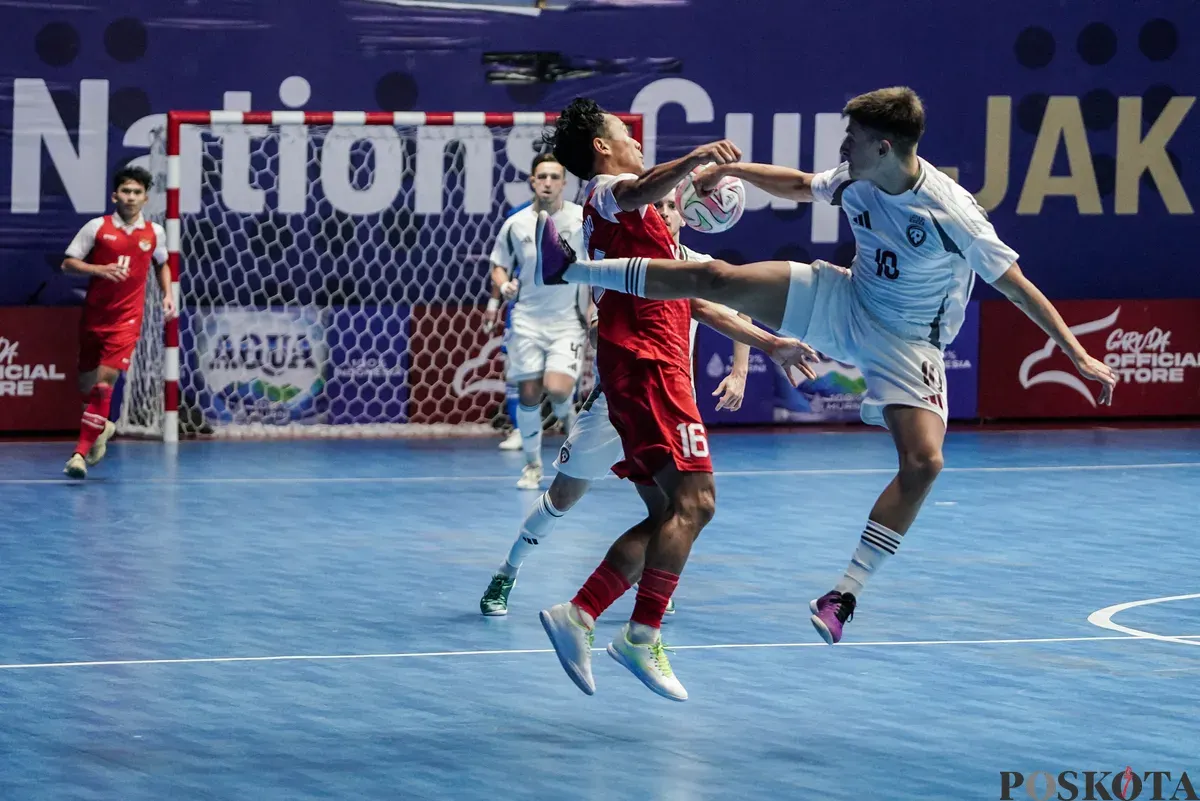 Pemain Timnas futsal Indonesia Guntur Ariwibowo berebut bola dengan pemain Timnas futsal Latvia Edgars Tarakanovs pada turnamen AQUA Futsal Four Nations Cup 2025 di GBK Basket Hall, Senayan, Jakarta, Minggu (21/9/2025). (Sumber: Poskota/Bilal Nugraha Ginanjar)