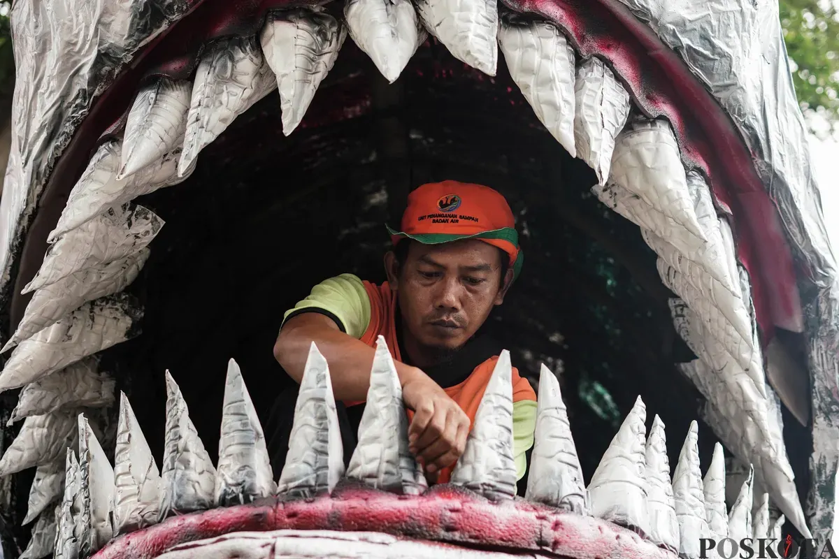 Petugas Unit Pengananan Sampah (UPS) Badan Air Kecamatan Johar Baru sibuk menyelesaikan perahu berbentuk ikan hiu di Johar Baru, Jakarta Pusat, Minggu, 21 September 2025. (Sumber: Poskota/Bilal Nugraha Ginanjar)