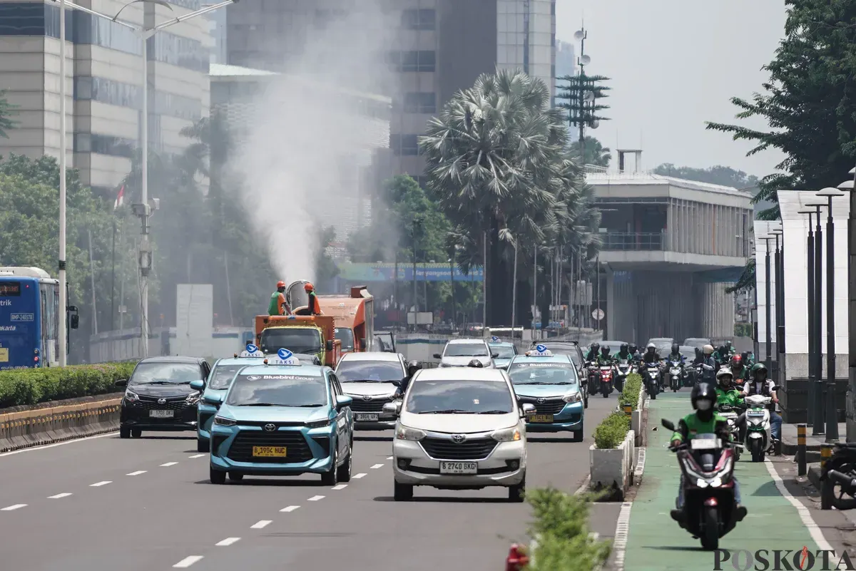 Petugas Dinas Lingkungan Hidup (DLH) DKI Jakarta menyemprotkan water mist di Kawasan Monas hingga Bundaran HI, Jakarta, Senin, 22 September 2025. (Sumber: Poskota/Bilal Nugraha Ginanjar)