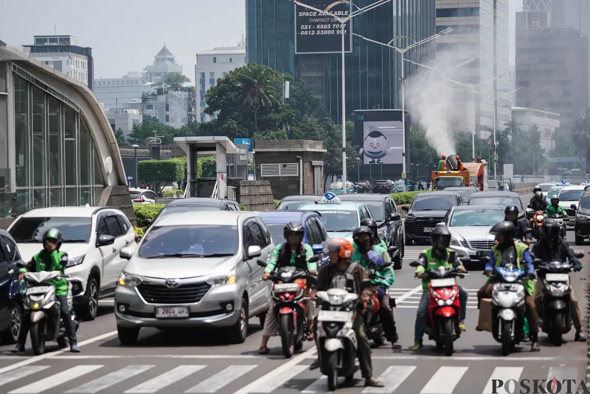 Petugas Dinas Lingkungan Hidup (DLH) DKI Jakarta menyemprotkan water mist di Kawasan Monas hingga Bundaran HI, Jakarta, Senin, 22 September 2025. (Sumber: Poskota/Bilal Nugraha Ginanjar)