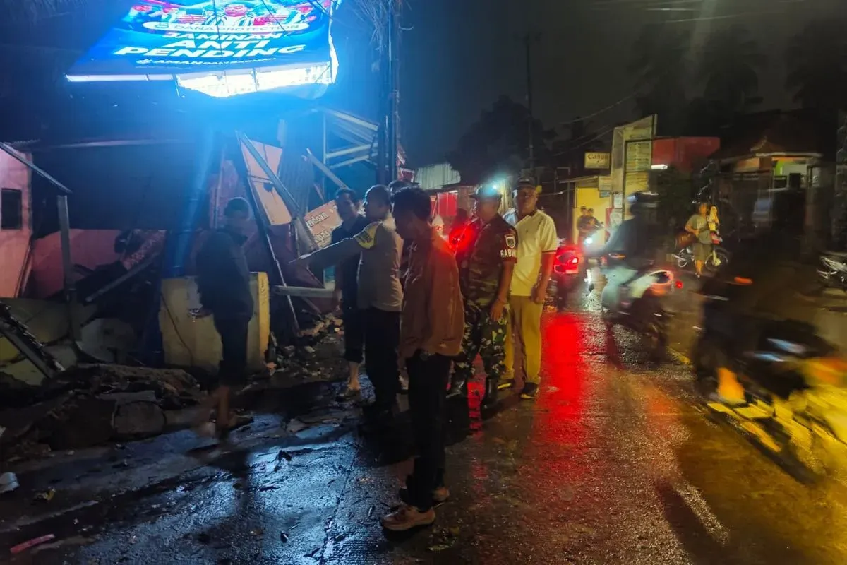 Petugas meninjau lokasi rubuhnya papan Reklame hingga menimpa tiga kios pedagang kali lima di Jalan Raya Sudimampir, Bojonggede, Kabupaten Bogor. (Sumber: Dok. Polsek Bojonggede)