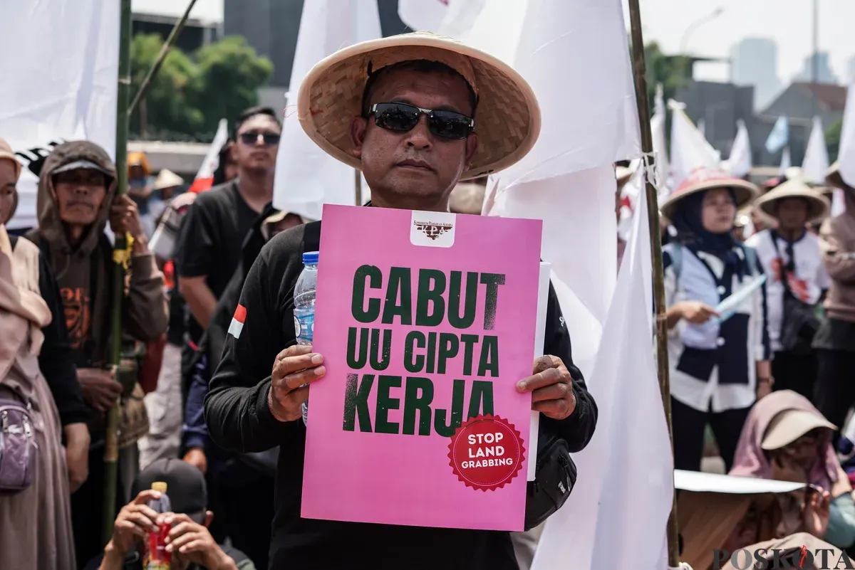 Pengunjuk rasa membawa poster saat aksi memperingati Hari Tani Nasional di depan Gedung DPR, Jakarta, Rabu, 24 September 2025 (Sumber: Poskota/Bilal Nugraha Ginanjar)