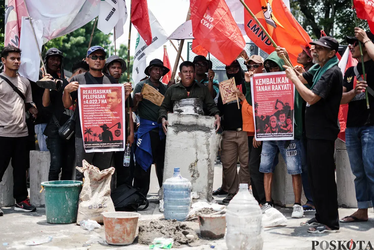 Pengunjuk rasa menggelar teatrikal mengecor tubuh saat aksi Hari Tani Nasional ke-65 di Jalan Merdeka Selatan, Rabu, 24 September 2025 (Sumber: Poskota/Bilal Nugraha Ginanjar)