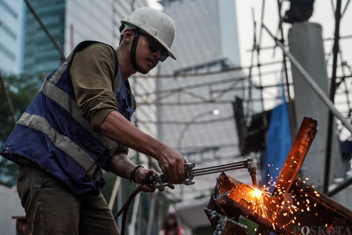 Pekerja mengelas besi Gerbang Tol Kuningan, Jakarta, Kamis, 25 September 2025. (Sumber: Poskota/Bilal Nugraha Ginanjar)