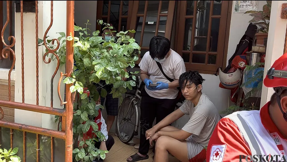 Salah satu warga diberikan oksigen karena mengalami sesak setelah berusaha memadamkan api yang membakar rumahnya di Kelurahan Tangki, Tamansari, Jakarta Barat, Minggu, 28 September 2025. (Sumber: POSKOTA | Foto: Pandi Ramedhan)