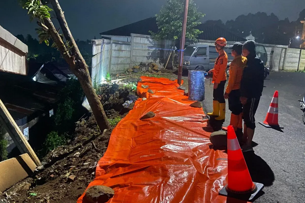 Petugas meninjau longsoran TPT di Mako Pusdik Reskrim, Megamendung, Kabupaten Bogor. (Sumber: Dok. BPBD Kabupaten Bogor)