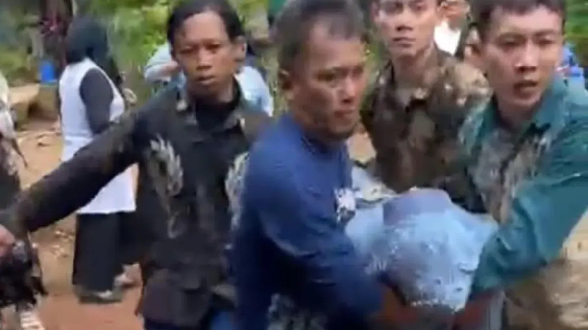 Sejumlah warga membopong istri korban Dadang yang pingsan setelah mengetahui suaminya jatuh dihantam balok kayu oleh preman kampung. (Sumber: Istimewa)