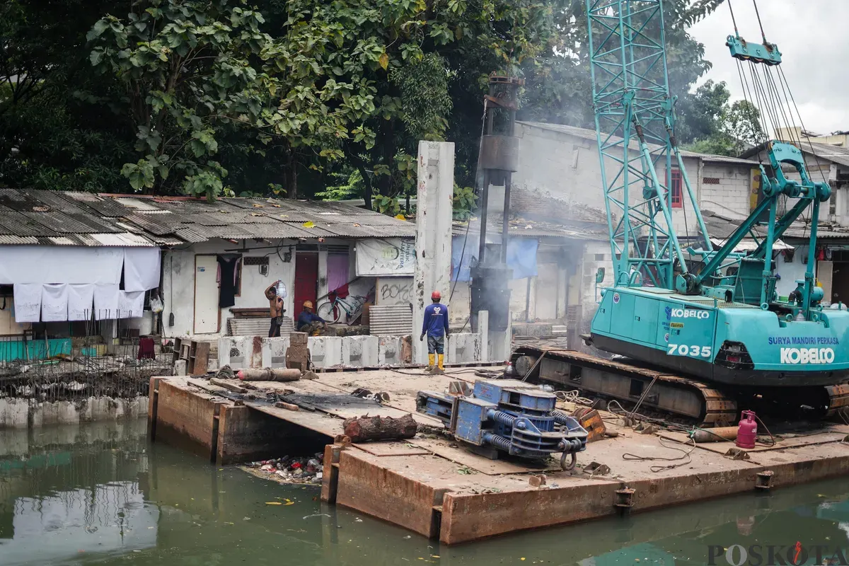 Pekerja memasang turap sheet pile di Kali Grogol, Kemanggisan, Jakarta, Senin, 2 Februari 2026. (Sumber: Poskota/Bilal Nugraha Ginanjar)