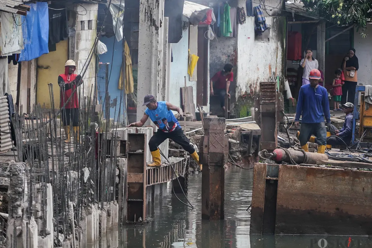 Pekerja memasang turap sheet pile di Kali Grogol, Kemanggisan, Jakarta, Senin, 2 Februari 2026. (Sumber: Poskota/Bilal Nugraha Ginanjar)