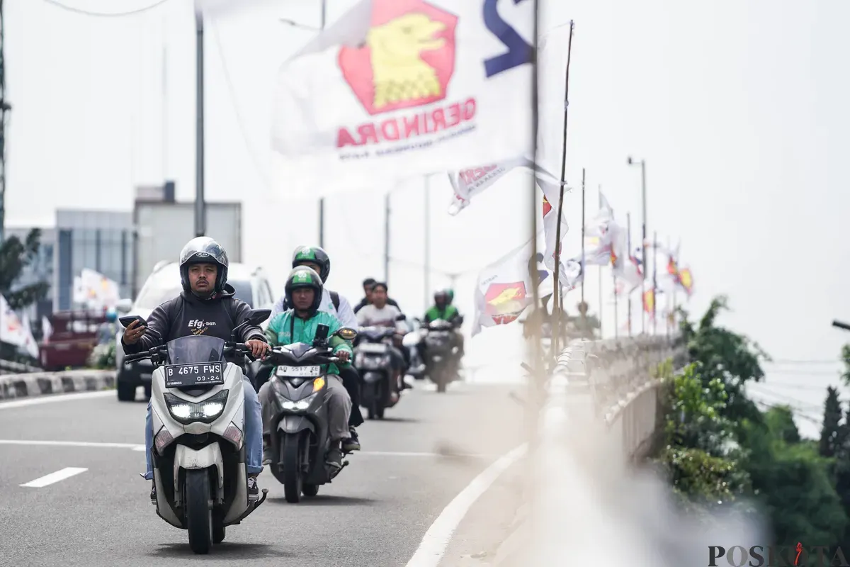 Pengendara sepeda motor melintas di dekat bendera partai politik yang terpasang di Jalan Layang Kemanggisan dan Jalan Pejompongan, Jakarta, Jumat, 6 Februari 2026. (Sumber: Poskota/Bilal Nugraha Ginanjar)
