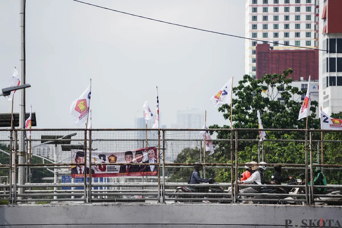 Pengendara sepeda motor melintas di dekat bendera partai politik yang terpasang di Jalan Layang Kemanggisan dan Jalan Pejompongan, Jakarta, Jumat, 6 Februari 2026. (Sumber: Poskota/Bilal Nugraha Ginanjar)