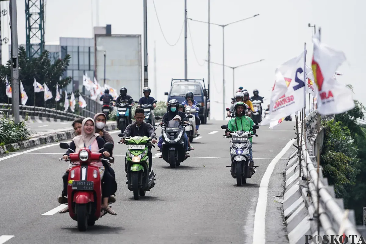 Pengendara sepeda motor melintas di dekat bendera partai politik yang terpasang di Jalan Layang Kemanggisan dan Jalan Pejompongan, Jakarta, Jumat, 6 Februari 2026. (Sumber: Poskota/Bilal Nugraha Ginanjar)
