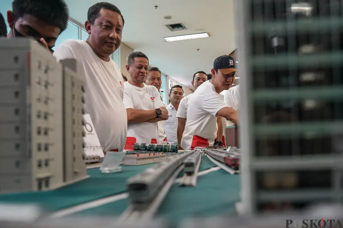 Direktur Utama KAI Commuter Purnomo Sidi (tengah) meninjau pameran diorama livery Kereta Commuter Indonesia (KCI) hasil kolaborasi dengan produsen model kereta asal Jepang, KATO, saat peluncuran C-Merch di Stasiun BNI City, Jakarta, Sabtu 14 Januari 2026. (Sumber: Poskota/Bilal Nugraha Ginanjar)