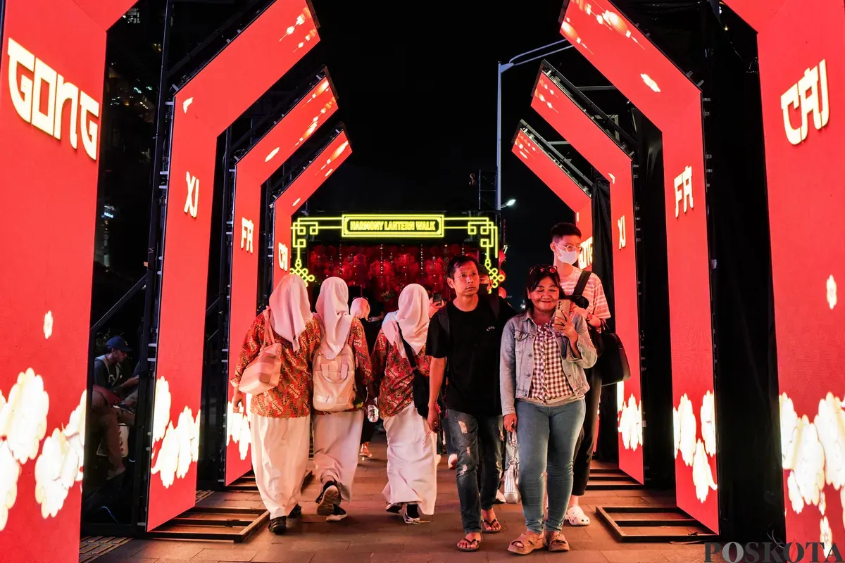 Warga berjalan melewati instalasi Festival Imlek Jakarta di kawasan Bundaran HI, Jakarta, Jumat, 13 Februari 2026. (Sumber: Poskota/Bilal Nugraha Ginanjar)
