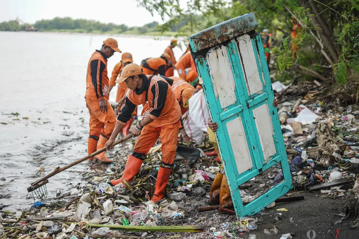 Petugas mengangkut sampah yang menumpuk di kawasan pesisir Marunda, Jakarta, Kamis, 12 Januari 2026. (Sumber: Poskota/Bilal Nugraha Ginanjar)