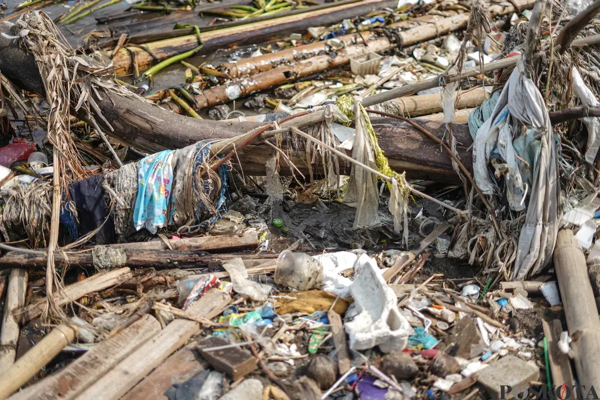 Petugas mengangkut sampah yang menumpuk di kawasan pesisir Marunda, Jakarta, Kamis, 12 Januari 2026. (Sumber: Poskota/Bilal Nugraha Ginanjar)