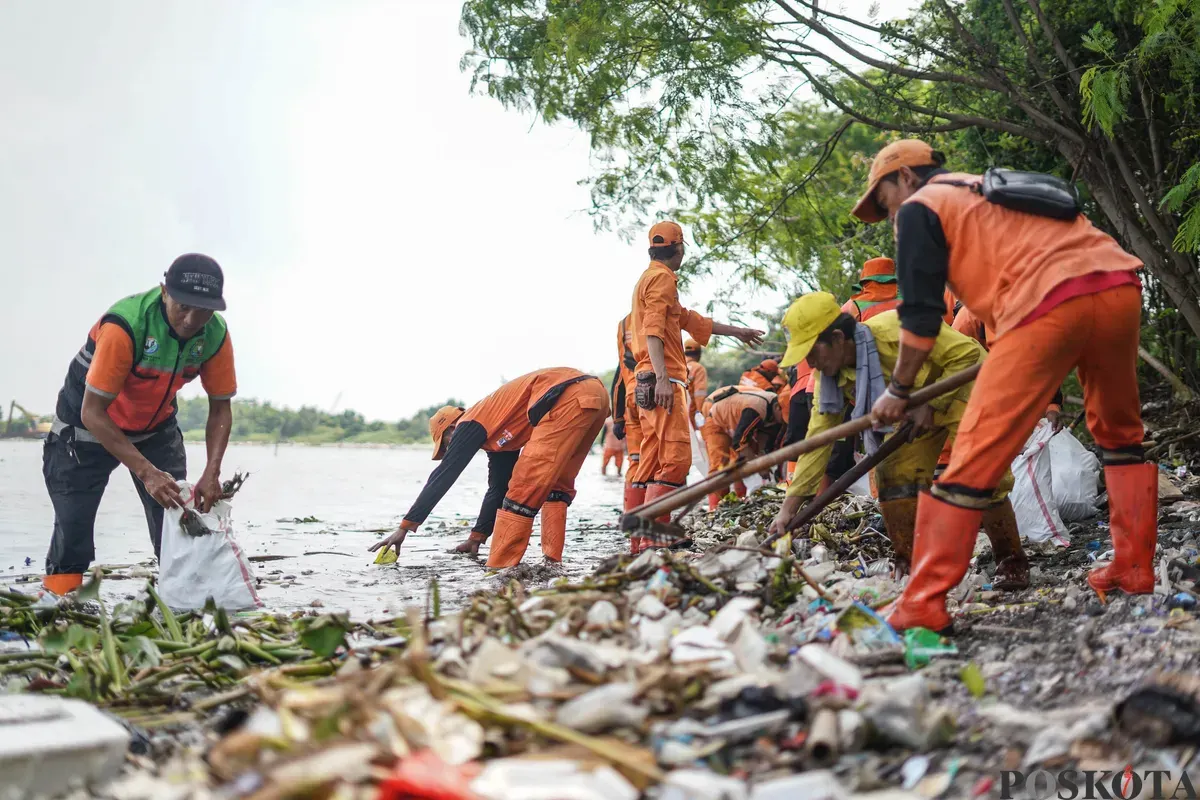 Petugas mengangkut sampah yang menumpuk di kawasan pesisir Marunda, Jakarta, Kamis, 12 Januari 2026. (Sumber: Poskota/Bilal Nugraha Ginanjar)