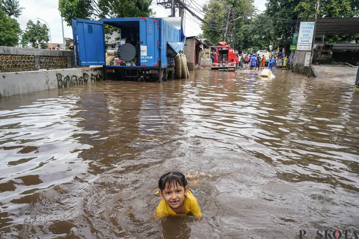 Seorang anak bermain pada genangan banjir di Jalan Swadharma Raya, Jakarta Selatan, Jumat, 20 Februari 2026. (Sumber: Poskota/Bilal Nugraha Ginanjar)