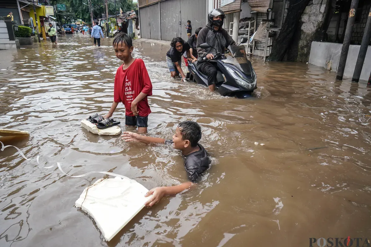 Warga mendorong motornya melintasi genangan banjir di Jalan Swadharma Raya, Jakarta Selatan, Jumat, 20 Februari 2026. (Sumber: Poskota/Bilal Nugraha Ginanjar)