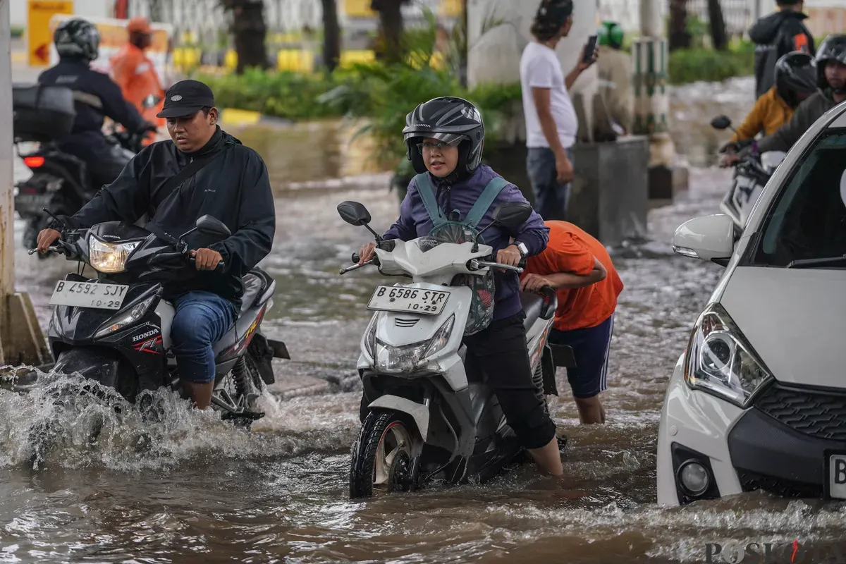Pengendara melintasi genangan banjir di Jalan Ciledug Raya, Jakarta Selatan, Jumat, 20 Februari 2026. (Sumber: Poskota/Bilal Nugraha Ginanjar)