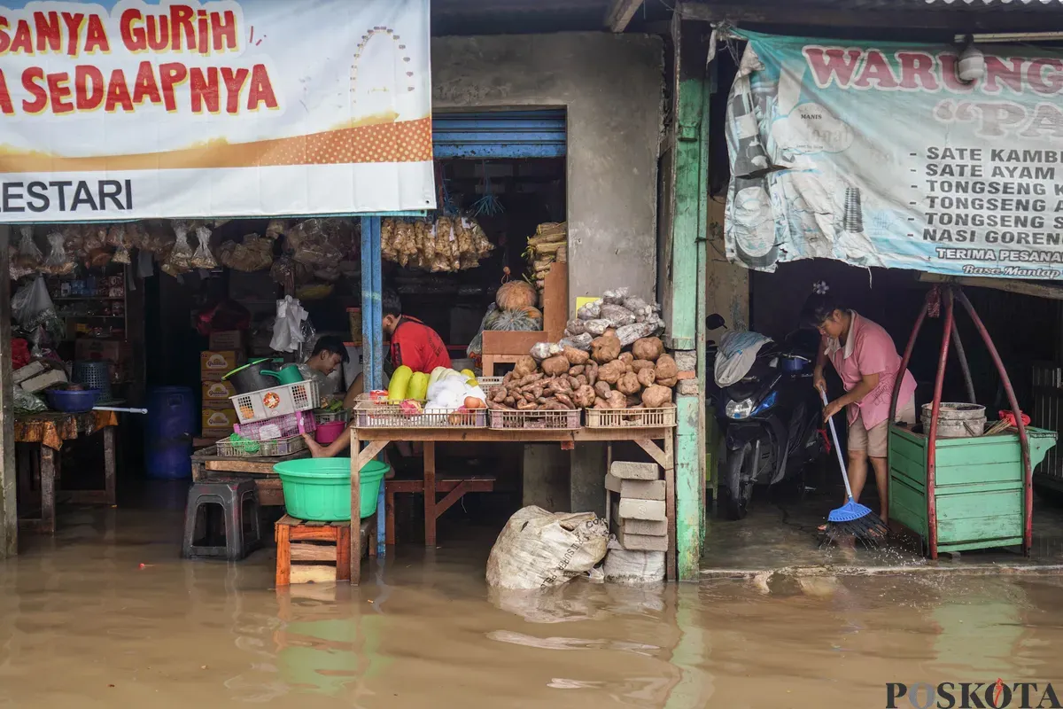 Warga melintasi genangan banjir di Jalan Swadharma Raya dan Jalan Ciledug Raya, Jakarta Selatan, Jumat, 20 Februari 2026. (Sumber: Poskota/Bilal Nugraha Ginanjar)