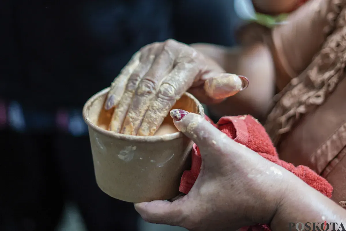 Orang Tugu menari sembari saling mencorengkan bedak saat mengikuti acara adat dan budaya Mandi-mandi di Kampung Tugu, Cilincing, Jakarta, Minggu, 4 Januari 2026. (Sumber: Poskota/Bilal Nugraha Ginanjar)