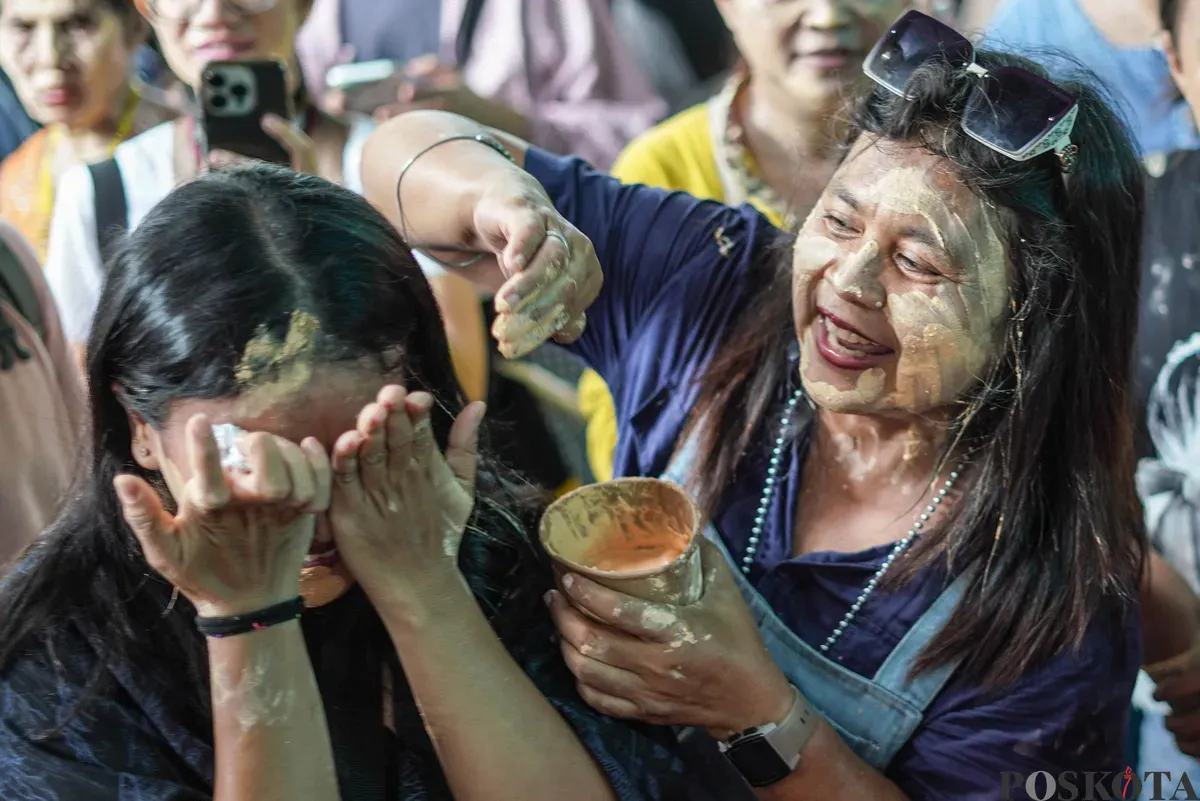 Orang Tugu menari sembari saling mencorengkan bedak saat mengikuti acara adat dan budaya Mandi-mandi di Kampung Tugu, Cilincing, Jakarta, Minggu, 4 Januari 2026. (Sumber: Poskota/Bilal Nugraha Ginanjar)