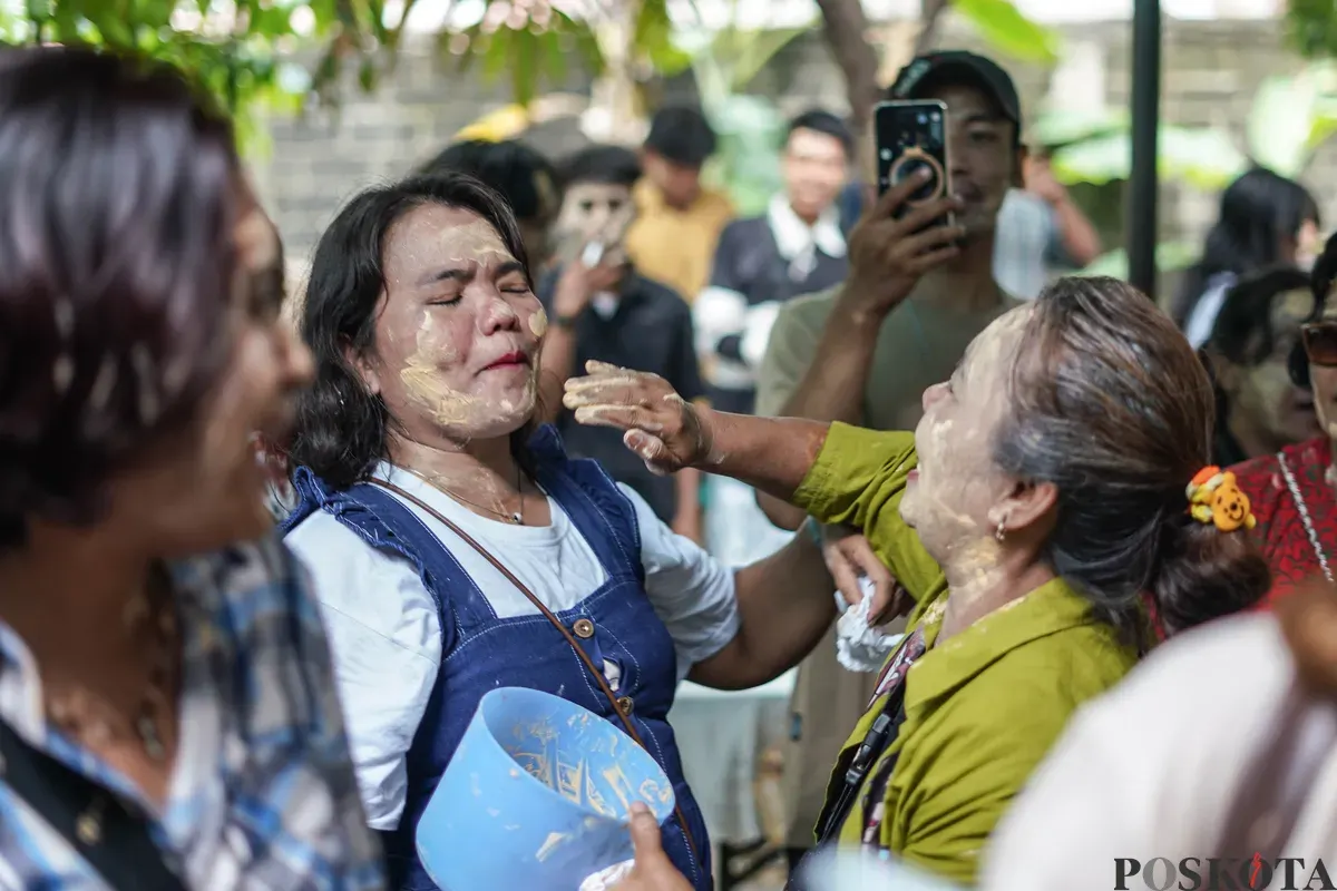 Orang Tugu menari sembari saling mencorengkan bedak saat mengikuti acara adat dan budaya Mandi-mandi di Kampung Tugu, Cilincing, Jakarta, Minggu, 4 Januari 2026. (Sumber: Poskota/Bilal Nugraha Ginanjar)