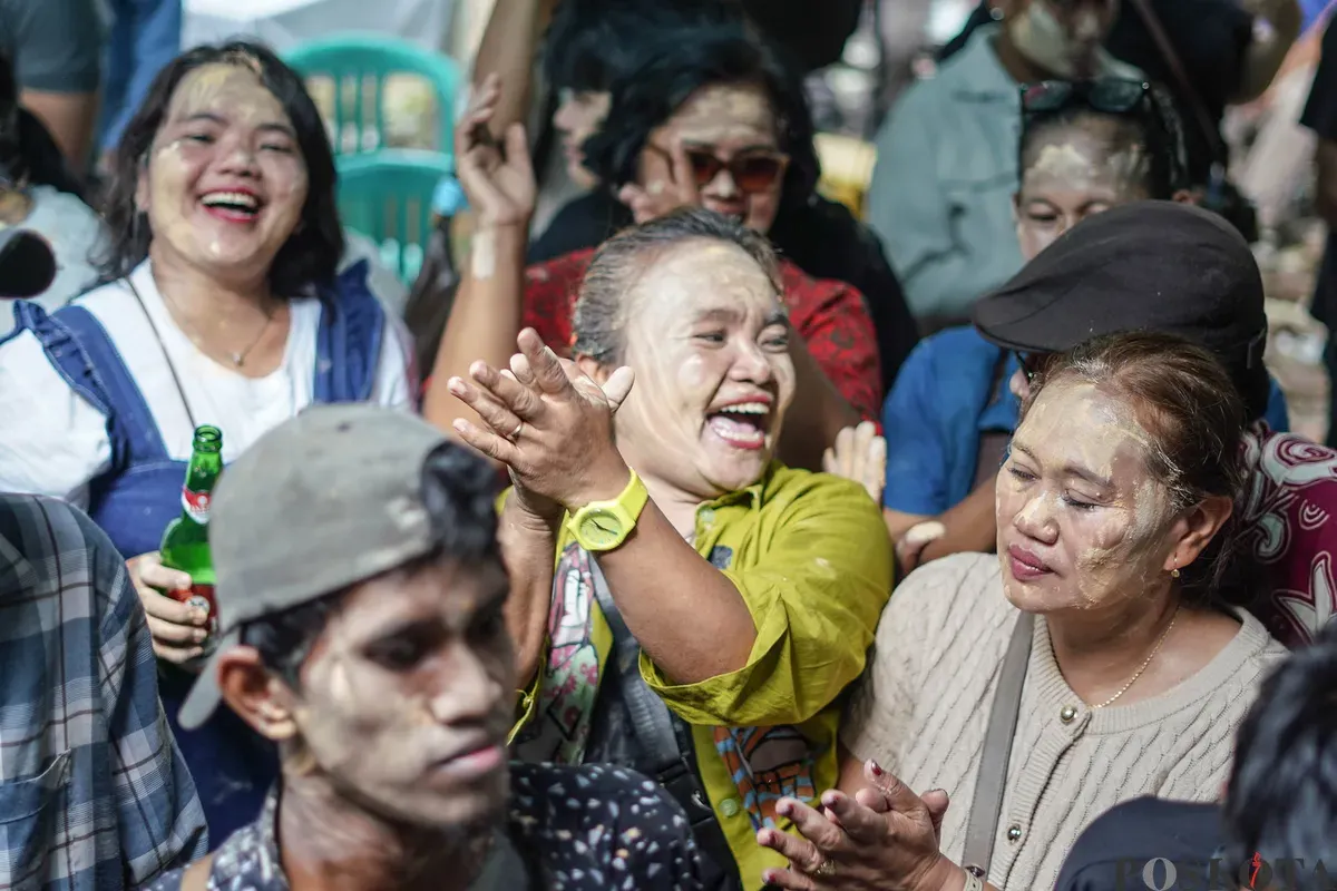 Orang Tugu menari sembari saling mencorengkan bedak saat mengikuti acara adat dan budaya Mandi-mandi di Kampung Tugu, Cilincing, Jakarta, Minggu, 4 Januari 2026 (Sumber: Poskota/Bilal Nugraha Ginanjar)