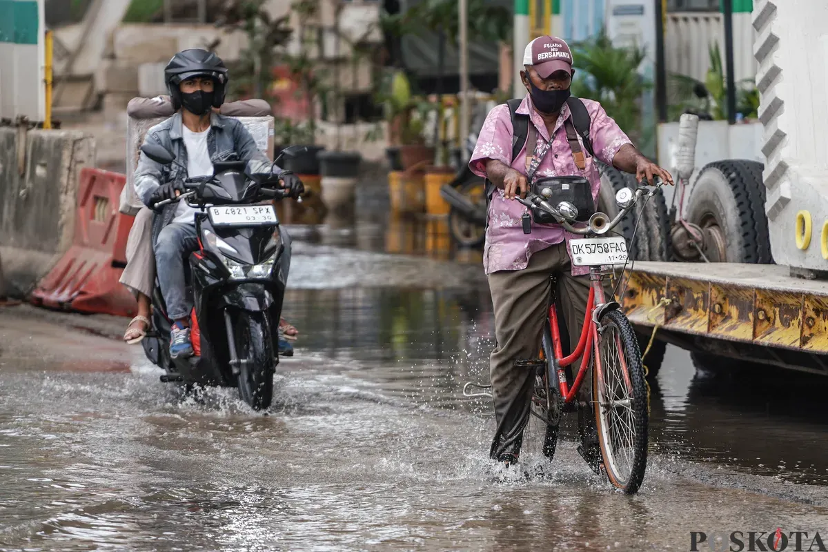 Pengendara melintasi banjir rob di Jalan R.E Martadinata, Tanjung Priok, Jakarta Utara, Selasa, 6 Januari 2026. (Sumber: Poskota/Bilal Nugraha Ginanjar)