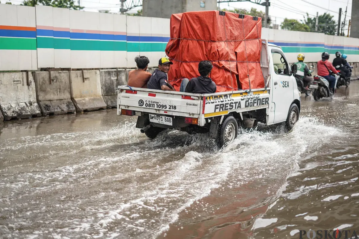 Pengendara melintasi banjir rob di Jalan R.E Martadinata, Tanjung Priok, Jakarta Utara, Selasa, 6 Januari 2026. (Sumber: Poskota/Bilal Nugraha Ginanjar)