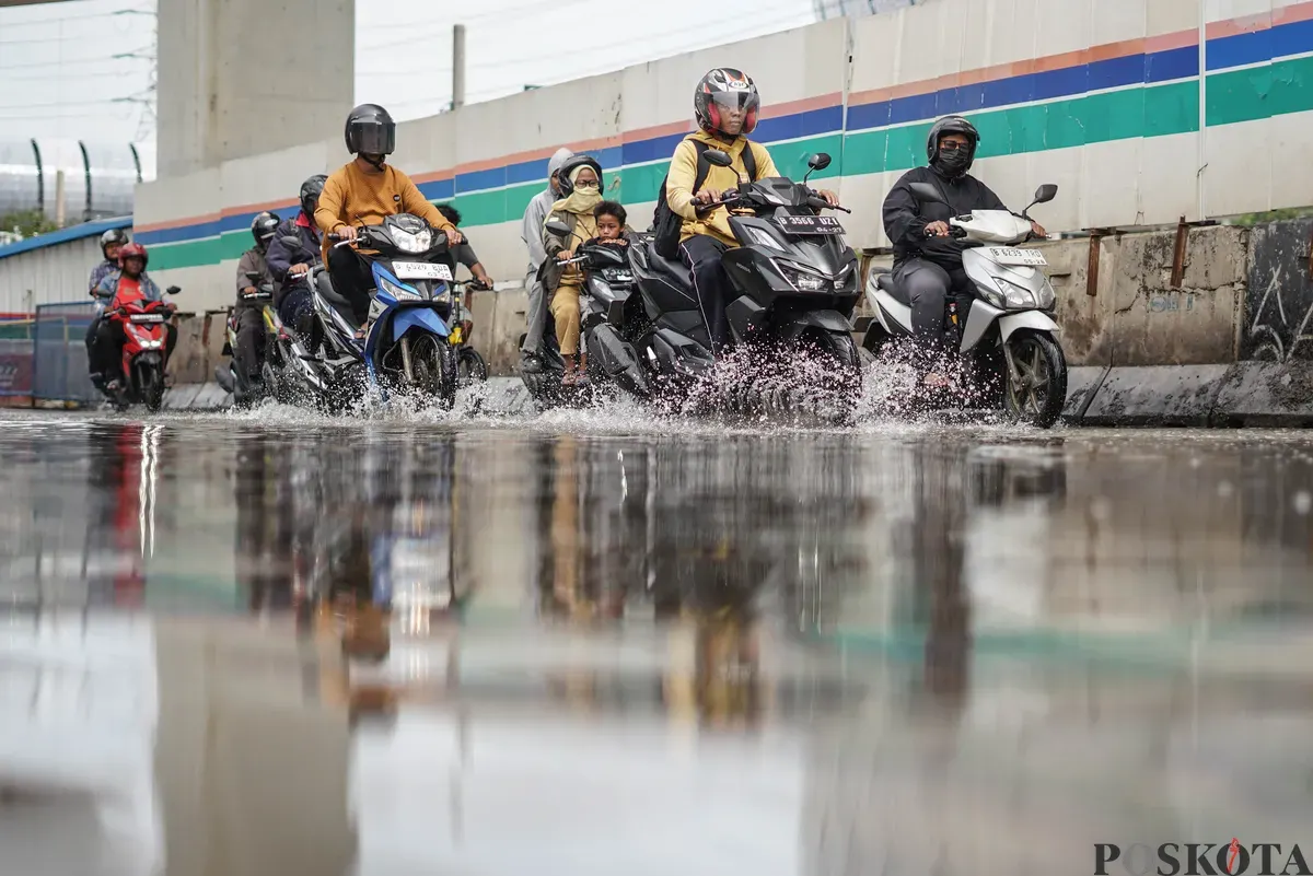 Pengendara melintasi banjir rob di Jalan R.E Martadinata, Tanjung Priok, Jakarta Utara, Selasa, 6 Januari 2026. (Sumber: Poskota/Bilal Nugraha Ginanjar)
