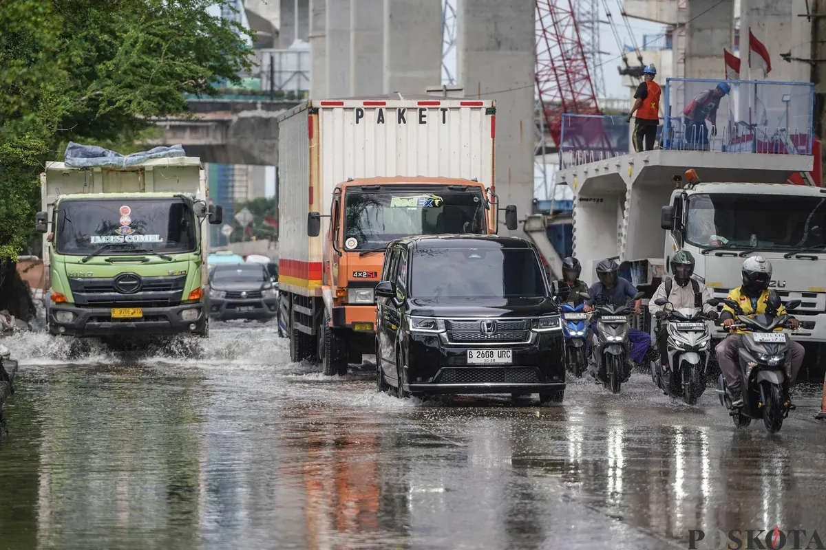Pengendara melintasi banjir rob di Jalan R.E Martadinata, Tanjung Priok, Jakarta Utara, Selasa, 6 Januari 2026. (Sumber: Poskota/Bilal Nugraha Ginanjar)