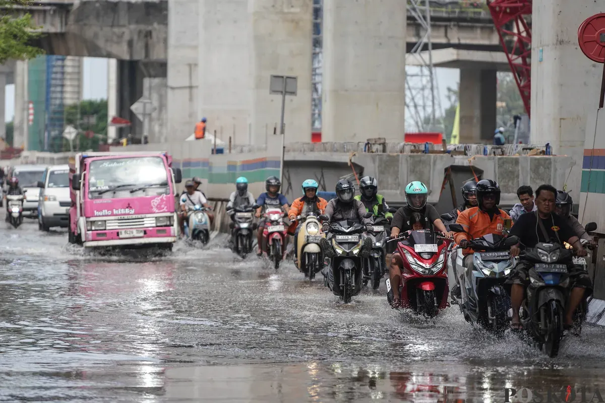 Pengendara melintasi banjir rob di Jalan R.E Martadinata, Tanjung Priok, Jakarta Utara, Selasa, 6 Januari 2026. (Sumber: Poskota/Bilal Nugraha Ginanjar)