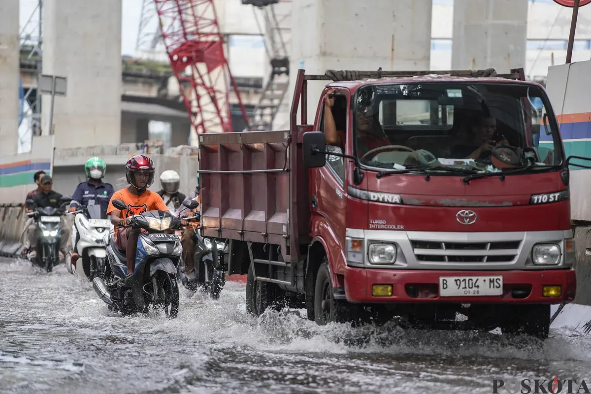 Pengendara melintasi banjir rob di Jalan R.E Martadinata, Tanjung Priok, Jakarta Utara, Selasa, 6 Januari 2026. (Sumber: Poskota/Bilal Nugraha Ginanjar)