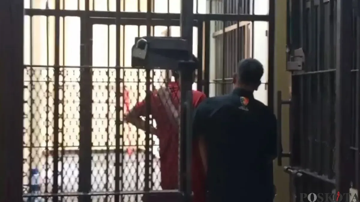 Kenakan baju orange, seorang Kades di Pandeglang saat dimasukan ke sel tahanan Polres Pandeglang. (Sumber: Poskota/Samsul Fatoni)