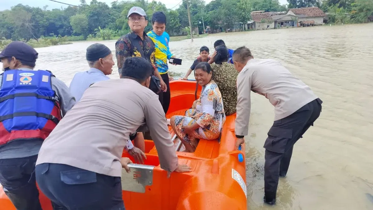 Petugas membantu masyarakat menyebrangi akibat akses jalan terendam. (Sumber: Dok. Polsek Pamarayan)