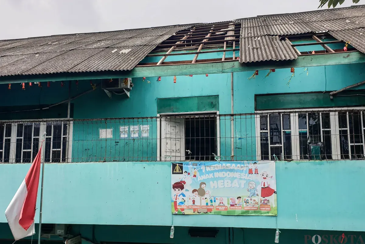 Petugas keamanan memeriksa bangunan yang hancur akibat angin puting beliung di Sekolah Dasar Islam (SDI) Baburidho, Kalibaru, Cilincing, Jakarta Utara, Selasa, 27 Januari 2026. (Sumber: Poskota/Bilal Nugraha Ginanjar)