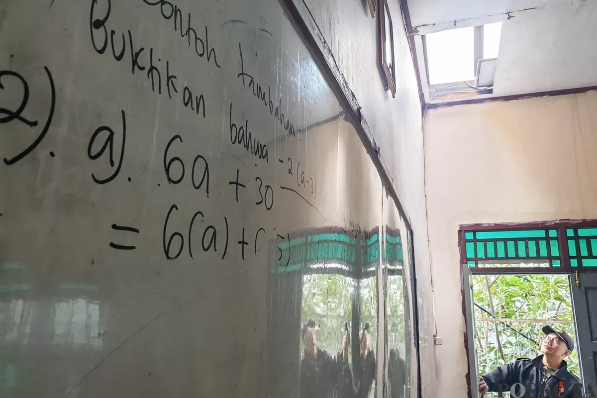 Petugas keamanan memeriksa bangunan yang hancur akibat angin puting beliung di Sekolah Dasar Islam (SDI) Baburidho, Kalibaru, Cilincing, Jakarta Utara, Selasa, 27 Januari 2026. (Sumber: Poskota/Bilal Nugraha Ginanjar)