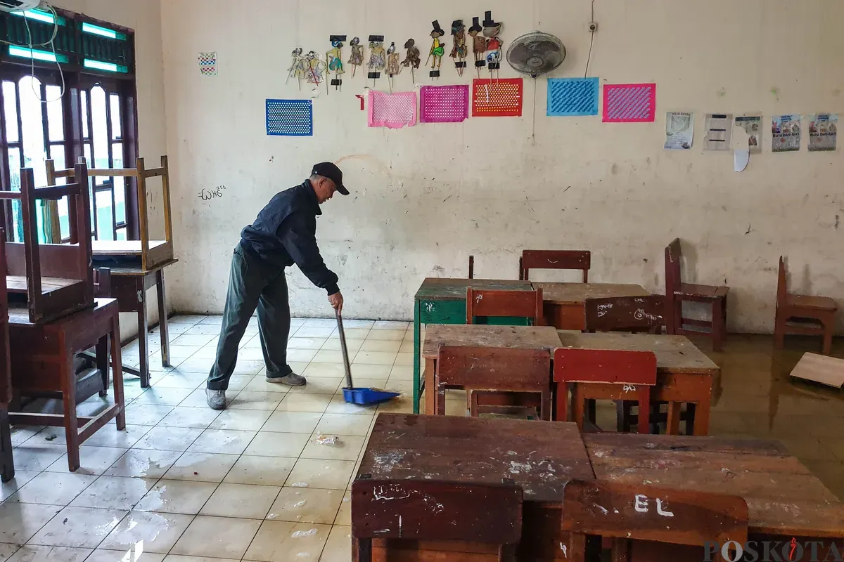 Petugas keamanan memeriksa bangunan yang hancur akibat angin puting beliung di Sekolah Dasar Islam (SDI) Baburidho, Kalibaru, Cilincing, Jakarta Utara, Selasa, 27 Januari 2026. (Sumber: Poskota/Bilal Nugraha Ginanjar)