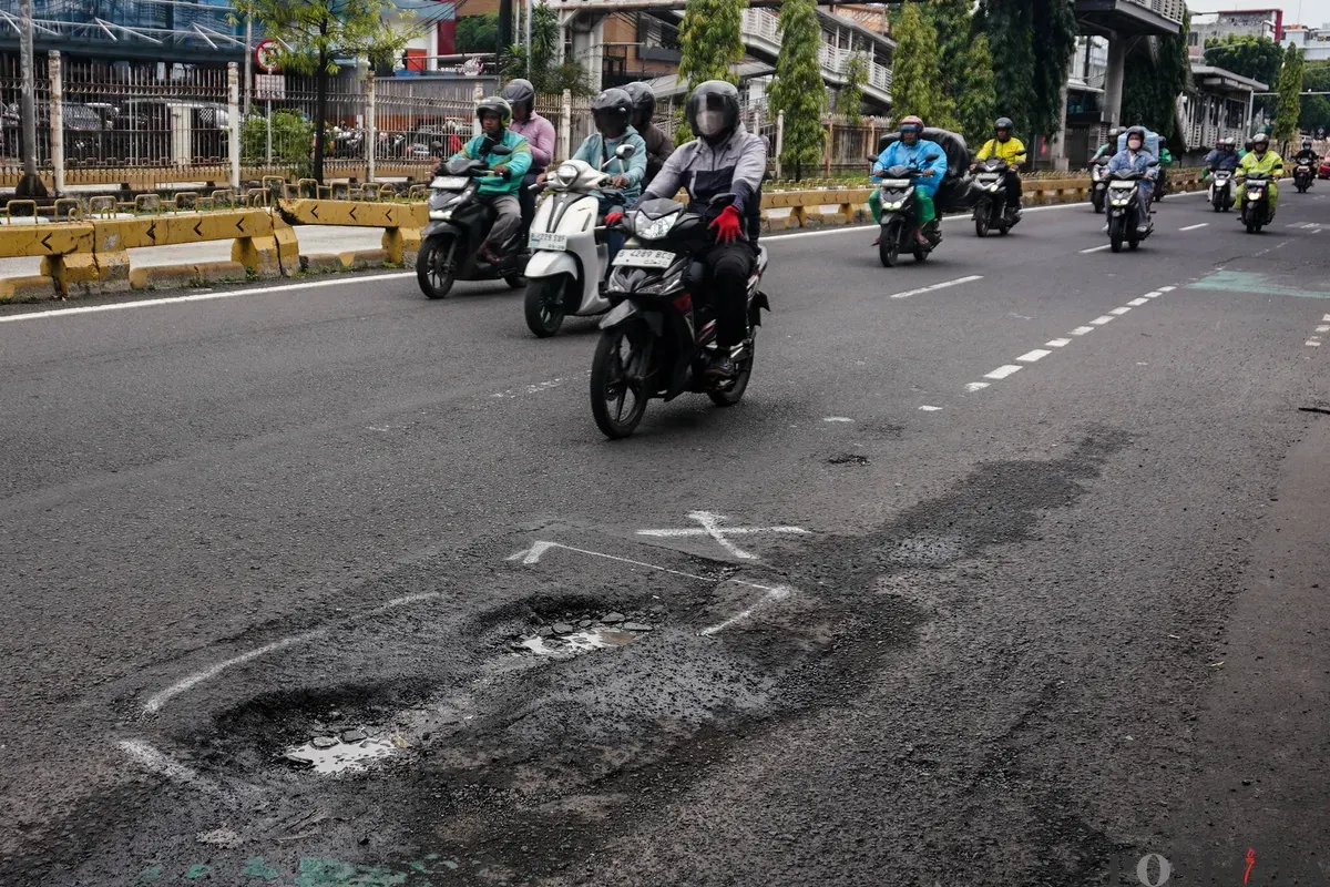 Pengendara melintasi jalanan berlubang di Jalan Palmerah, Mampang Prapatan Raya, dan Gatot Subroto, Jakarta, Rabu, 28 Januari 2025. (Sumber: Poskota/Bilal Nugraha Ginanjar)