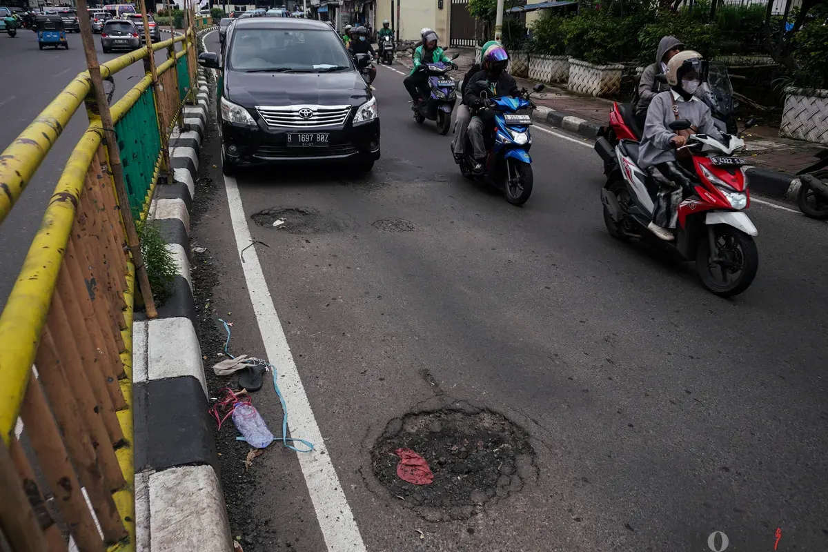Pengendara melintasi jalanan berlubang di Jalan Palmerah, Mampang Prapatan Raya, dan Gatot Subroto, Jakarta, Rabu, 28 Januari 2025. (Sumber: Poskota/Bilal Nugraha Ginanjar)