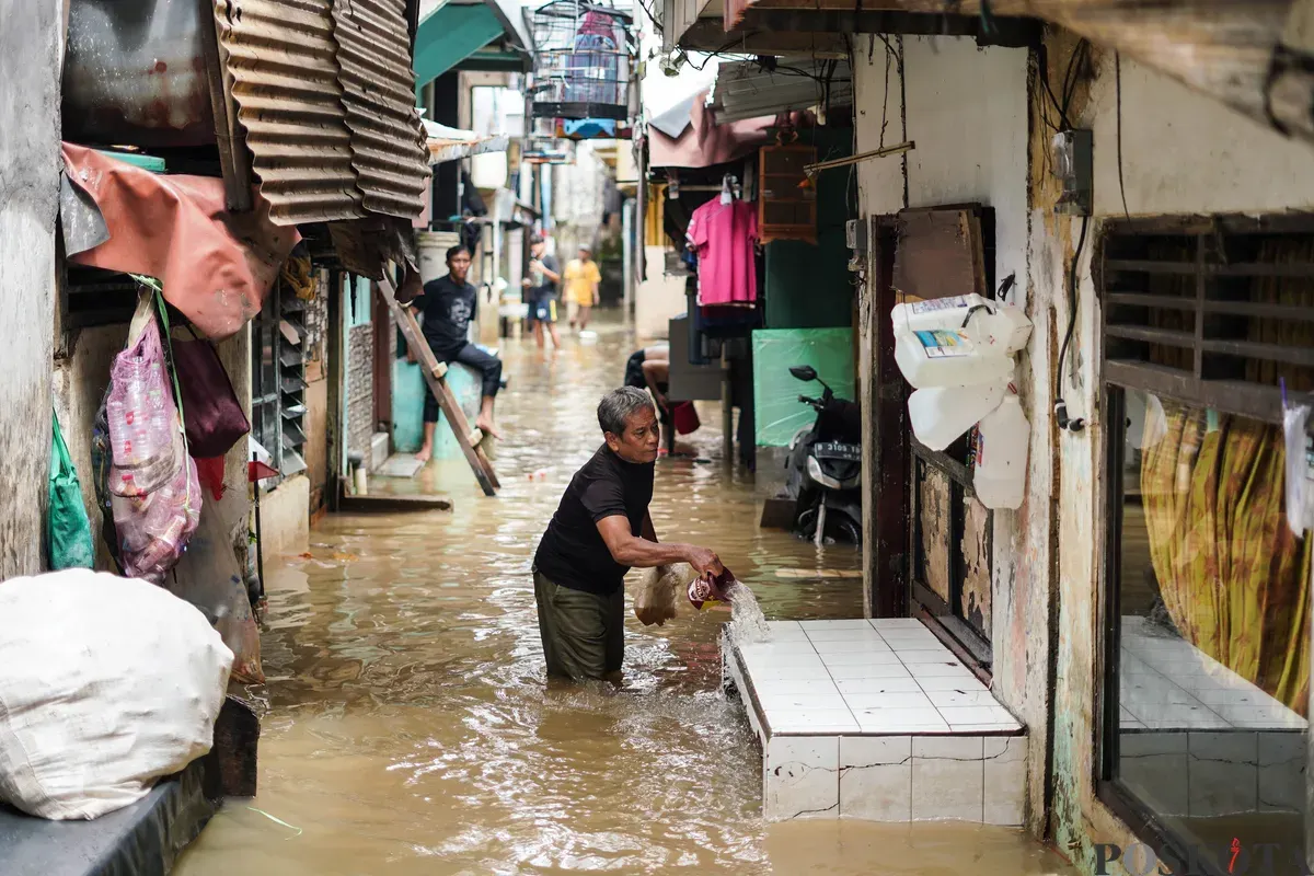 Warga berjalan melintasi banjir yang menggenangi kawasan Kebon Pala, Jakarta Timur, Jumat, 30 Januari 2026 (Sumber: Poskota/Bilal Nugraha Ginanjar)